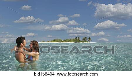 Caucasian couple hugging in tropical ocean View Large Photo Image Picture - Caucasian couple hugging in tropical ocean. Fotosearch