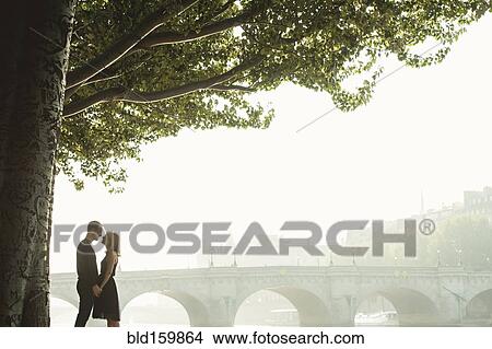 Caucasian couple kissing near bridge, Paris, Ile-de-France, France View Large Photo Image Picture - Caucasian couple kissing near bridge, Paris, Ile-de-France, France. Fotosearch