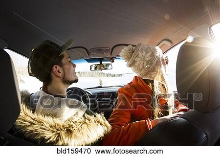 Stock Image - Caucasian couple looking out car window. Fotosearch