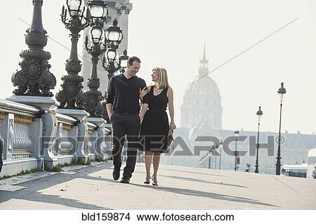 Caucasian couple walking on urban bridge View Large Photo Image Picture - Caucasian couple walking on urban bridge. Fotosearch