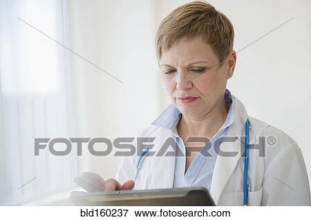 Stock Photo - Caucasian doctor using digital tablet. Fotosearch