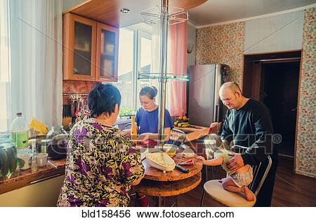 Stock Photograph - Caucasian family cooking in kitchen. Fotosearch