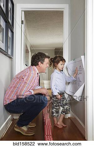Stock Image - Caucasian father and daughter talking in hallway. Fotosearch