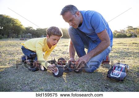 Caucasian father and son playing with remote control cars in field View Large Photo Image Stock Photography - Caucasian father and son playing with remote control cars in field. Fotosearch