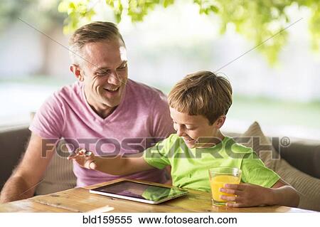 Caucasian father and son using digital tablet outdoors View Large Photo Image Stock Photography - Caucasian father and son using digital tablet outdoors. Fotosearch