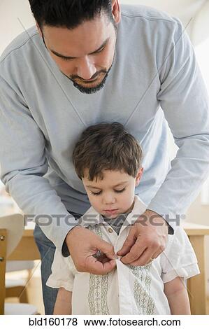 Caucasian father buttoning shirt for son View Large Photo Image Stock Photo - Caucasian father buttoning shirt for son. Fotosearch