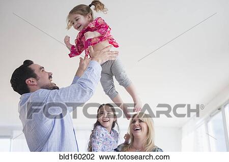 Caucasian father tossing daughter in air View Large Photo Image Stock Image - Caucasian father tossing daughter in air. Fotosearch