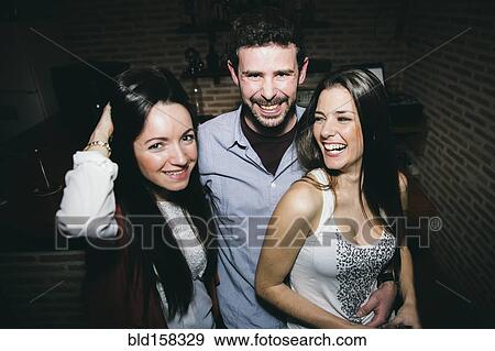 Stock Photo - Caucasian friends laughing in nightclub. Fotosearch