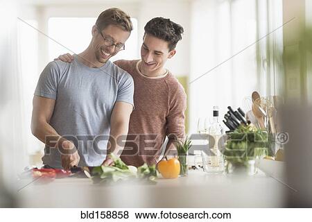 Caucasian gay couple cooking in kitchen View Large Photo Image Stock Photo - Caucasian gay couple cooking in kitchen. Fotosearch