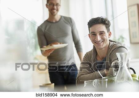Picture - Caucasian gay couple eating breakfast together. Fotosearch