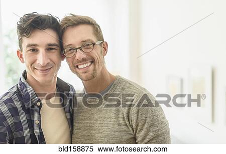 Stock Photography - Caucasian gay couple smiling in home. Fotosearch