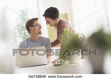 Caucasian gay couple using laptop View Large Photo Image Stock Photo - Caucasian gay couple using laptop. Fotosearch