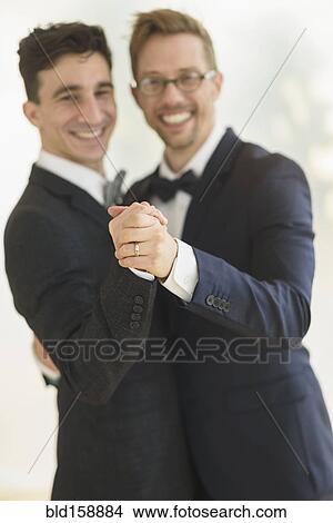 Picture - Caucasian gay grooms dancing at wedding. Fotosearch
