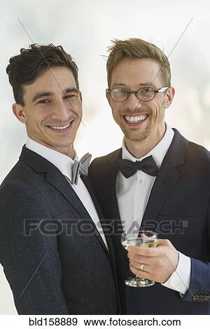 Caucasian gay grooms drinking champagne at wedding View Large Photo Image Stock Photo - Caucasian gay grooms drinking champagne at wedding. Fotosearch