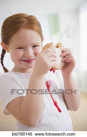 Stock Photography - Caucasian girl eating messy jelly donut. Fotosearch