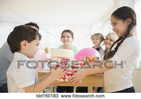 Caucasian girl giving brother birthday gift at party View Large Photo Image Stock Image - Caucasian girl giving brother birthday gift at party. Fotosearch