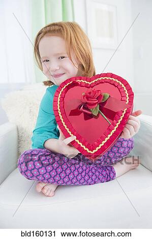 Caucasian girl holding gift box of candy View Large Photo Image Stock Image - Caucasian girl holding gift box of candy. Fotosearch