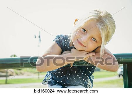 Picture - Caucasian girl leaning on farm fence. Fotosearch
