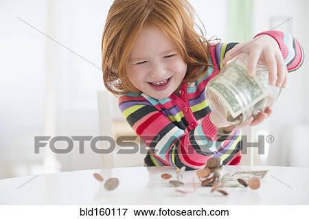 Stock Photo - Caucasian girl pouring money from change jar. Fotosearch