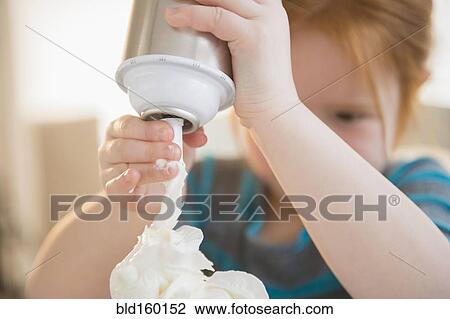 Caucasian girl spraying whipped cream View Large Photo Image Stock Image - Caucasian girl spraying whipped cream. Fotosearch