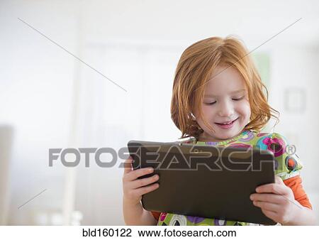 Stock Image - Caucasian girl using digital tablet. Fotosearch