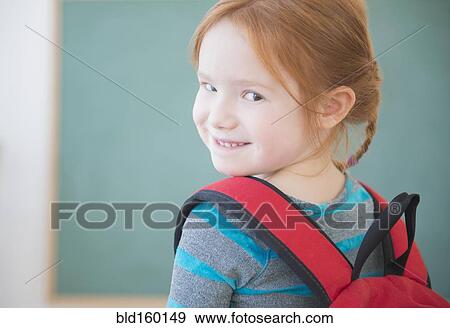 Caucasian girl wearing backpack in classroom View Large Photo Image Stock Photo - Caucasian girl wearing backpack in classroom. Fotosearch