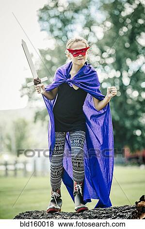 Stock Photo - Caucasian girl wearing costume and playing with sword. Fotosearch