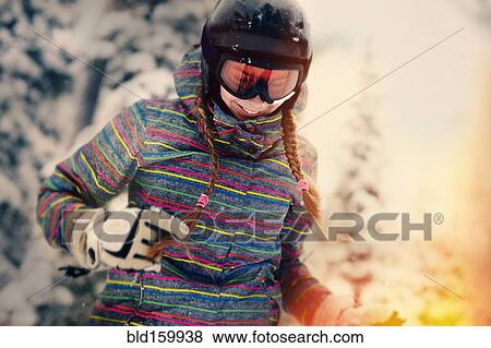 Stock Photo - Caucasian girl wearing helmet and goggles in winter. Fotosearch