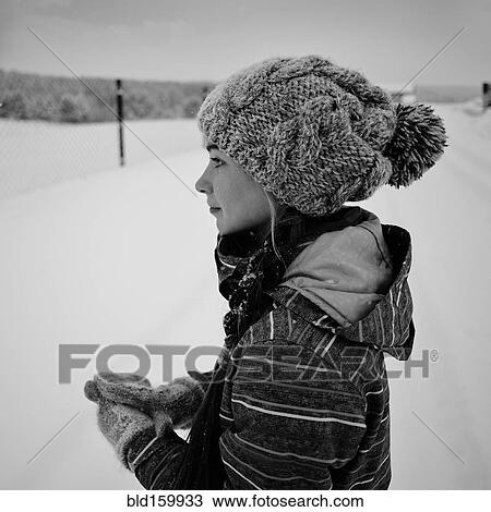 Stock Image - Caucasian girl wearing knit cap and gloves in snow. Fotosearch