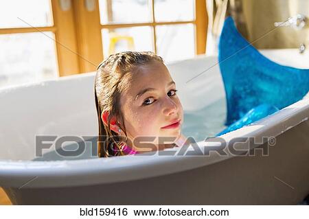 Caucasian girl wearing mermaid tail in bath View Large Photo Image Stock Photograph - Caucasian girl wearing mermaid tail in bath. Fotosearch