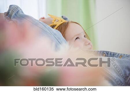 Stock Photography - Caucasian girl wearing tiara on sofa. Fotosearch