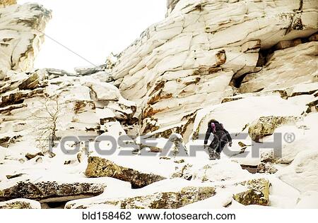 Caucasian hiker climbing snowy rock formations View Large Photo Image Stock Image - Caucasian hiker climbing snowy rock formations. Fotosearch