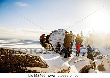 Stock Photograph - Caucasian hikers climbing snowy rock formations. Fotosearch