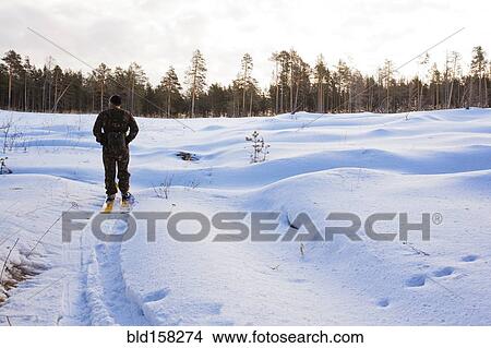 Picture - Caucasian man cross country skiing in snowy field. Fotosearch