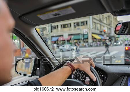 Stock Image - Caucasian man driving car in city. Fotosearch