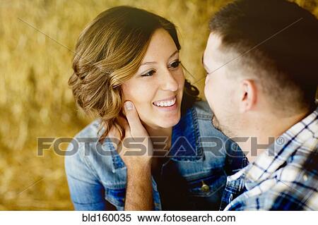 Stock Photography - Caucasian man holding face of girlfriend. Fotosearch