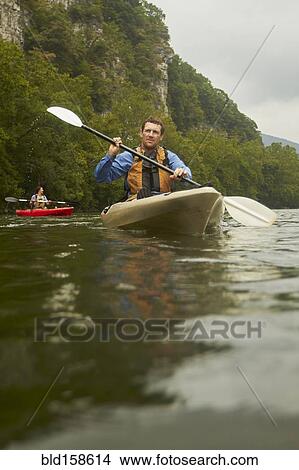 Caucasian man paddling kayak on remote river View Large Photo Image Picture - Caucasian man paddling kayak on remote river. Fotosearch