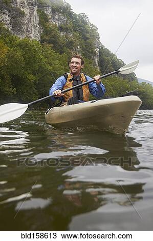 Caucasian man paddling kayak on remote river View Large Photo Image Stock Image - Caucasian man paddling kayak on remote river. Fotosearch