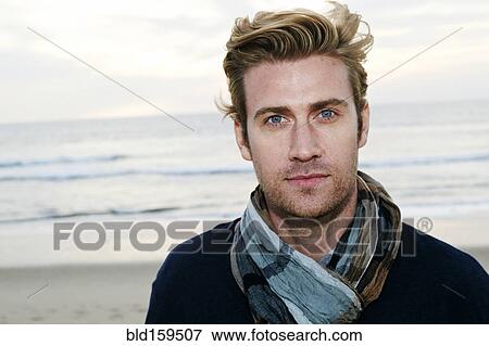 Stock Photo - Caucasian man standing on beach. Fotosearch