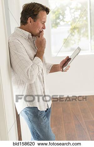 Stock Image - Caucasian man using digital tablet. Fotosearch