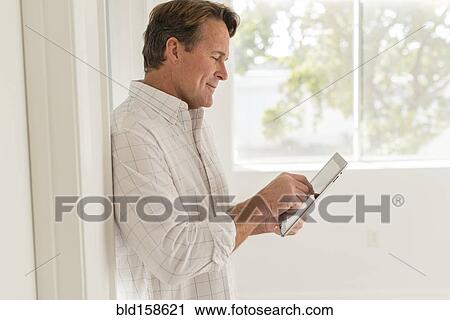 Caucasian man using digital tablet View Large Photo Image Stock Image - Caucasian man using digital tablet. Fotosearch