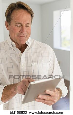Stock Image - Caucasian man using digital tablet. Fotosearch