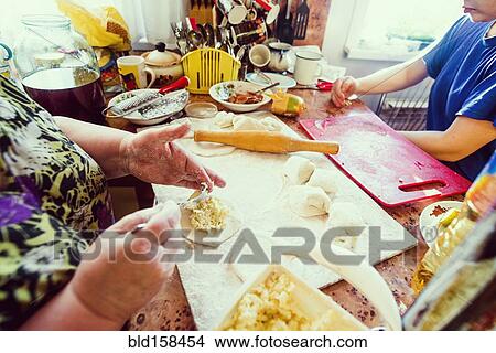 Picture - Caucasian mother and daughter cooking in kitchen. Fotosearch