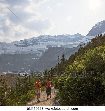 Stock Photo - Caucasian mother and daughter hiking on Six Glaciers Trail, Banff, Alberta, Canada. Fotosearch