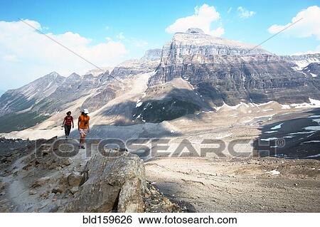 Stock Photograph - Caucasian mother and daughter hiking on Six Glaciers Trail, Banff, Alberta, Canada. Fotosearch