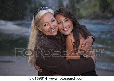 Caucasian mother and daughter hugging near lake View Large Photo Image Picture - Caucasian mother and daughter hugging near lake. Fotosearch