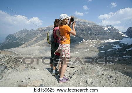 Caucasian mother and daughter photographing scenic view of Six Glaciers Trail, Banff, Alberta, Canada View Large Photo Image Stock Photography - Caucasian mother and daughter photographing scenic view of Six Glaciers Trail, Banff, Alberta, Canada. Fotosearch