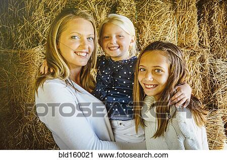 Caucasian mother and daughters smiling near haystacks View Large Photo Image Stock Image - Caucasian mother and daughters smiling near haystacks. Fotosearch