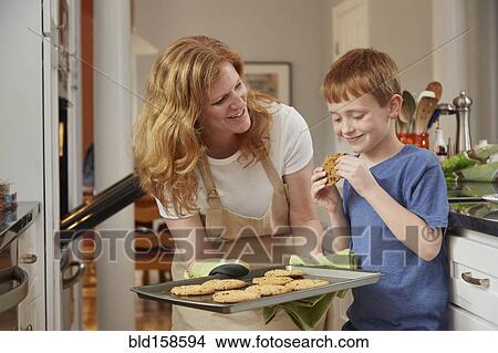 Picture - Caucasian mother and son baking cookies in kitchen. Fotosearch