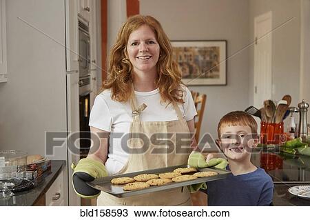 Stock Image - Caucasian mother and son baking cookies in kitchen. Fotosearch